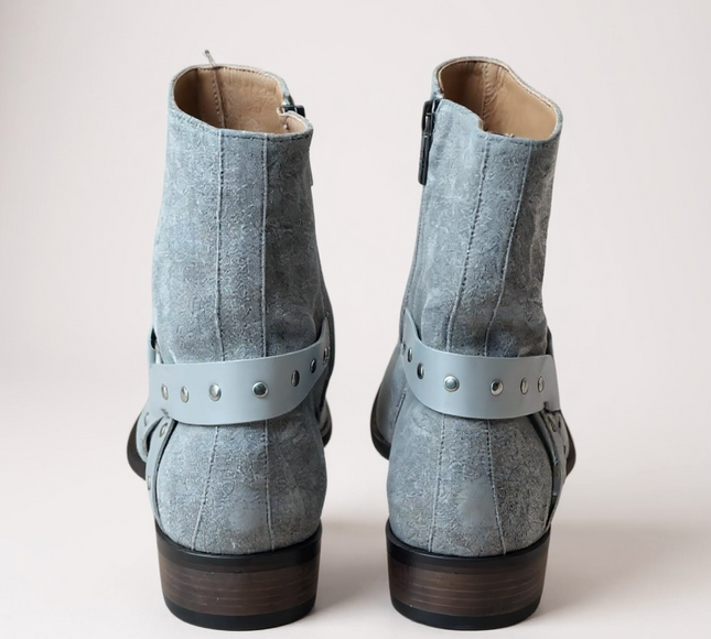 JO Ghost Pair of light blue suede boots with straps on a light gray 
