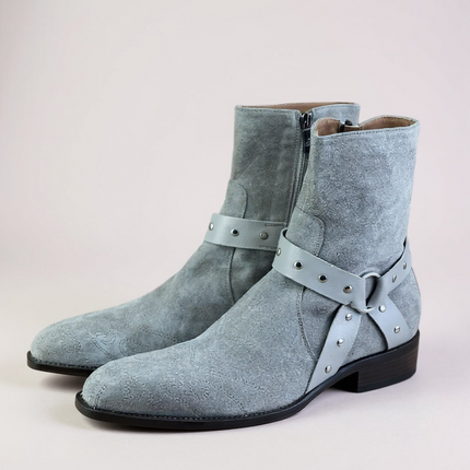 JO Ghost Pair of light blue suede boots with straps on a light gray 
